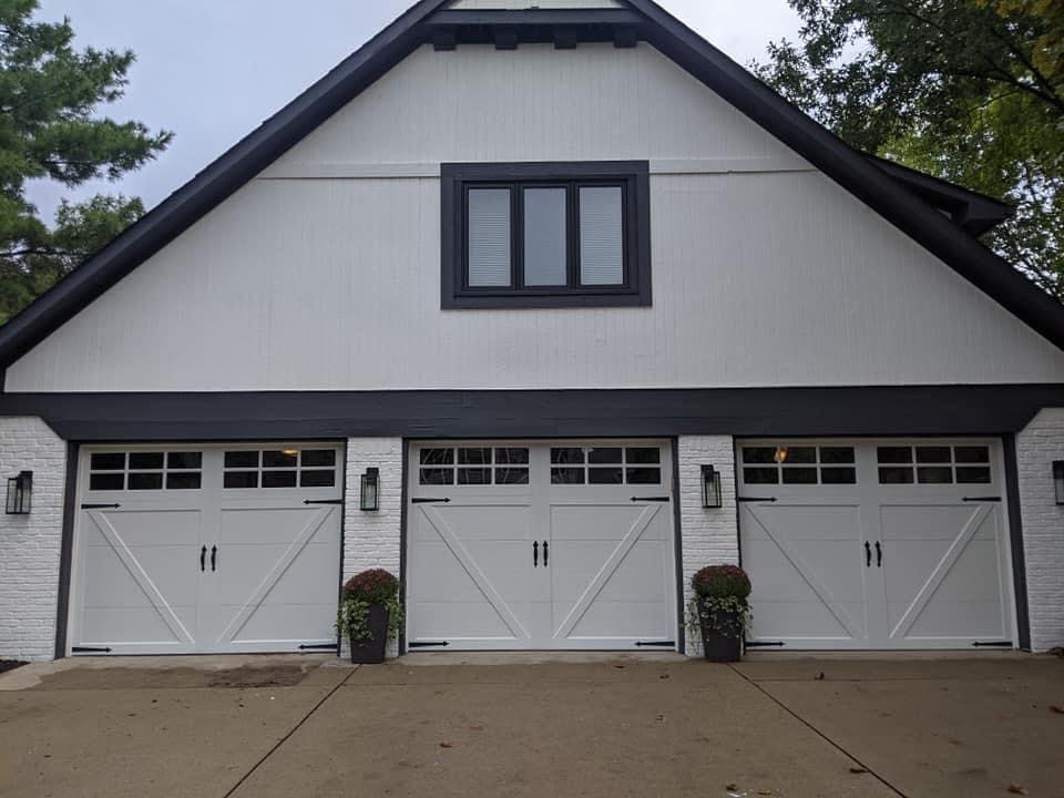 Three white carriage-style garage doors with black trim